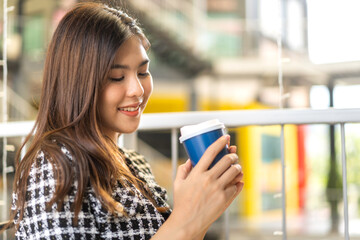 Fototapeta premium Portrait of smiling happy cheerful beauty pretty woman relaxing looking at camara and drinking cup of hot coffee or tea.Girl felling enjoy having breakfast in holiday morning vacation at cafe