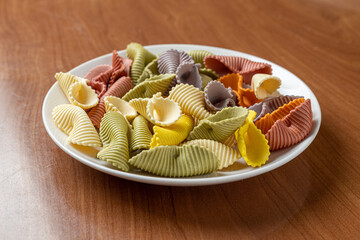 Colorful pasta background. Top view of five colors pasta shells .Heap of colorful spiral pasta,macaroni texture.