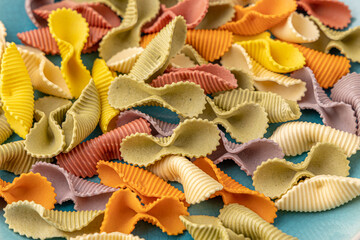 Colorful pasta background. Top view of five colors pasta shells .Heap of colorful spiral pasta,macaroni texture.