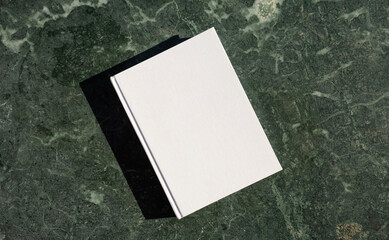 Fototapeta premium blank book mockup on green marble stone coffee table , shadow overlay