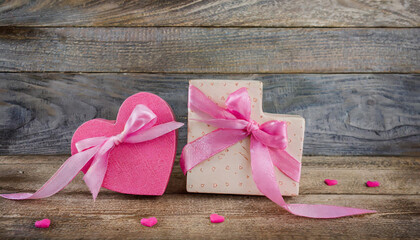  pink hearts, a gift box on wooden background.