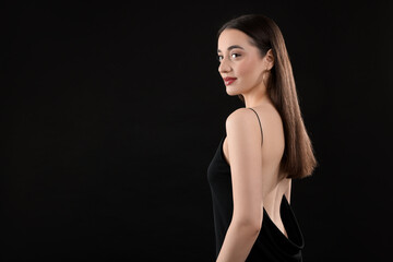 Fototapeta premium Beautiful young woman on black background, space for text