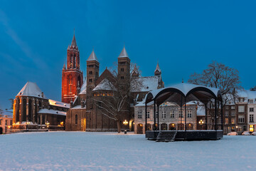 Maastricht, Netherlands 01-19-2024 Basilica of Saint Servatius and the Vrijthof square during twilight, covered with fresh snow in January.  