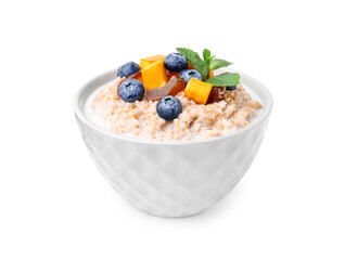 Tasty wheat porridge with milk, pumpkin, dates and blueberries in bowl isolated on white