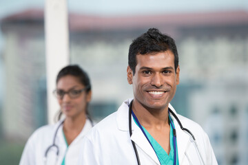 Male Indian doctor standing with his colleague