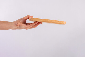 Wooden plate in hand on white background.