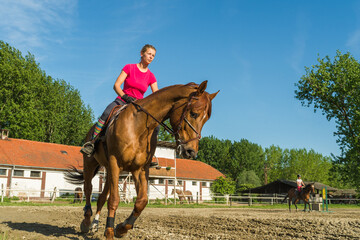 Woman rider rides horse on ranch
