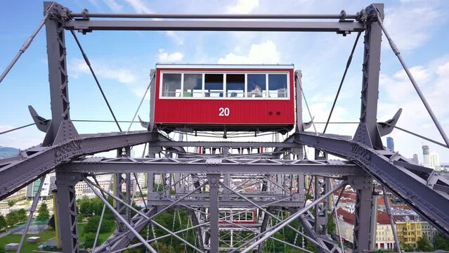 Vienna Ferris Wheel at the Prater amusement park, historic red cabins on wheel. Popular landmark, sightseeing activity for tourists in Austria. fun fair ride.