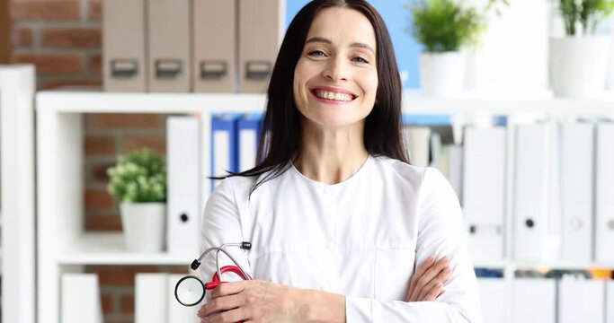 Smiling woman doctor crossing her arms portrait 4k movie slow motion. Medical consulting concept