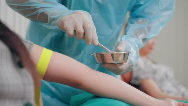 Doctor fumble blood vessel on arm of blood donor asian woman preparing steps during venipuncture to blood donation at blood bank. Asian woman donating blood on medical bed at hospital.