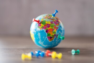 Closeup image of colorful pins on world globe. Travel destination, planning vacation concept. © izzuan