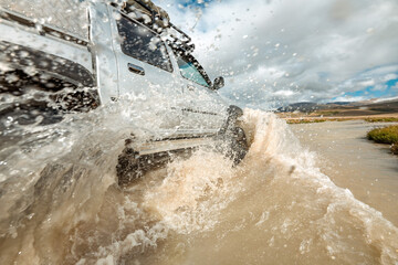 4x4 ready car is crossing white mountain river with big wave and splashes © cppzone