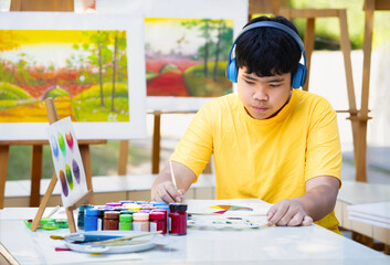 asian teens boy concentrate on painting in school art club. concept of school elective activities,...