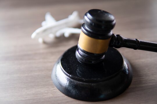 Closeup image of judge gavel and toy plane on table. Aviation law concept.