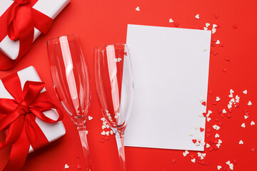 Champagne and gift: Celebratory duo on a red background with text space