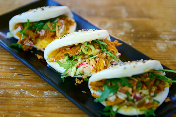 Crispy pork salad roll, Thai food on black plate.