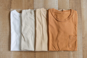 Top view of brown color variants t-shirts on wood plank background