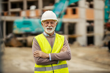 Portrait of a happy confident construction site manager standing at building area.