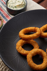 Close-up of fried onion rings in a black plate