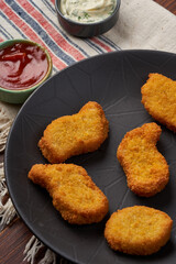 Close-up photo of fried nuggets on a black plate