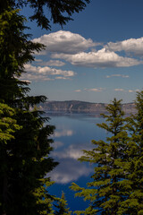 A stunning view of Crater Lake through the trees, capturing the breathtaking beauty of this natural wonder. Image shows the Crater Lake National Park.