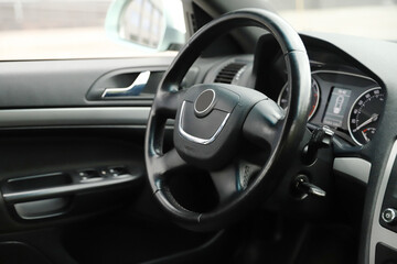 black interior of a modern car. Dashboard. Luxury leather steering wheel. Auto controls. Car doors inside. Car chairs and seats. Car sofa. Back and front row. Interior and door trim. High quality