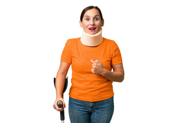 Middle-aged caucasian woman wearing neck brace over isolated background with surprise facial...