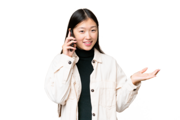 Young Asian woman over isolated chroma key background keeping a conversation with the mobile phone with someone