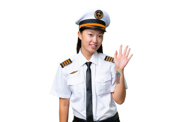 Airplane pilot Asian woman over isolated background saluting with hand with happy expression © luismolinero
