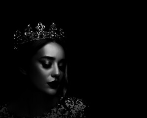 Silhouette of woman with crown in darkness. Portrait on black background © New Africa