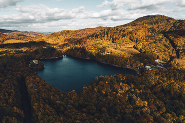 Naklejka premium Top view of lake in the middle of autumn forest in Slovakia. Europe traveling concept.
