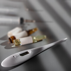 Set of medical devices consisting of syringe, thermometer and ampoules on gray background