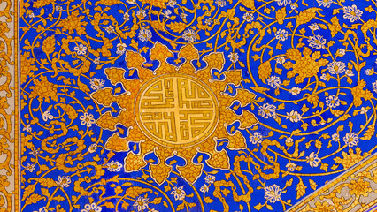 Ornament pattern at the wall of Tilya Kori Madrasa. Name of God (Allah) in Arab language inside ornament flower. Gold and blue. Traditional Uzbek decorative art. Samarkand, Uzbekistan