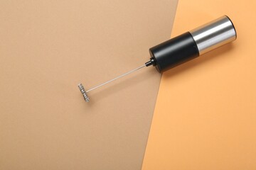 Milk frother wand on color background, top view. Space for text