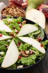 Delicious pear salad in bowl on table, closeup