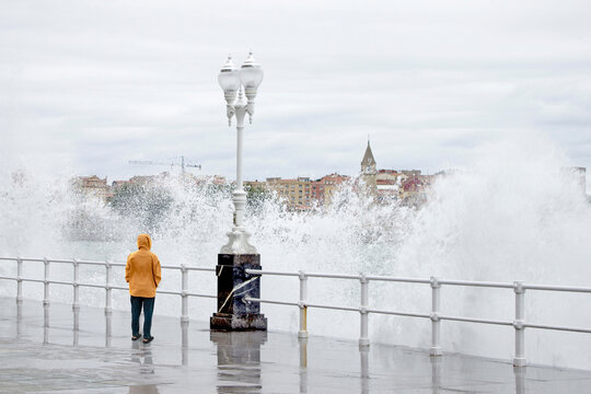 Mature man standing near railing in front of sea at Gijon, Asturias, Spain