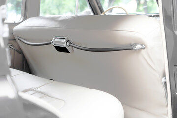 retro car interior. Vintage dashboards. Luxury leather steering wheel. Auto controls.
White interior. Car chairs and seats. Car sofa. Back and front row. Interior and door trim. Classic look