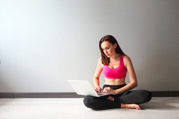 Sporty young brunette woman using laptop