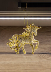 A sparkling transparent figurine of a fairy-tale horse hangs on a thin thread.