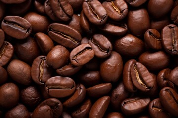 Fototapeta premium Close up view of dark fresh roasted coffee beans on coffee beans background. Closeup of coffee beans scattered background
