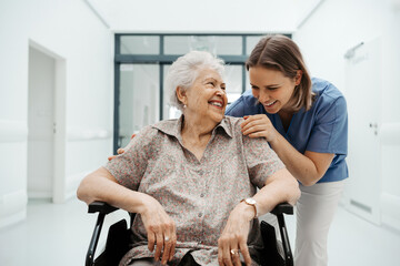Portrait of nurse and senior patient talking in hospital corridor. Emotional support for elderly...