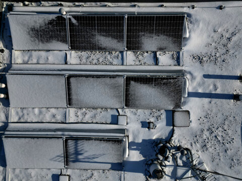 water heating in collectors on gable and flat roofs work when sun is shining. frost covered with layer of snow or frost must be plastered, otherwise effectiveness will recuced in row white silhoulett
