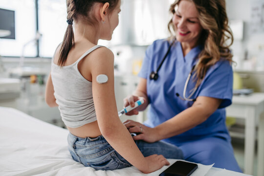 Nurse injecting insulin in diabetic girl belly. Close up of young girl with type 1 diabetes taking insuling with syringe needle.