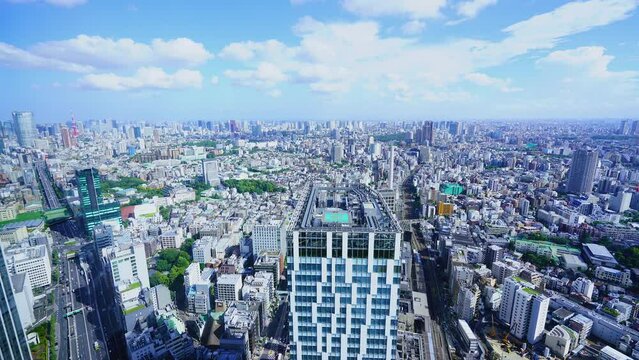 Tokyo Timelapse - Sunny partly cloudy sky and  Roppongi Minato Ward direction cityscape seen from Shibuya