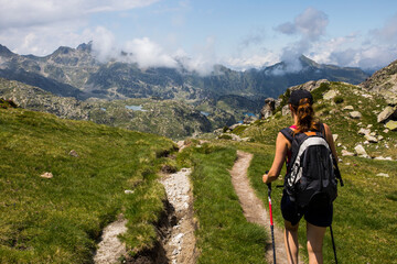 Obraz premium Young hiker girl summit to Ratera Peak in Aiguestortes and Sant Maurici National Park, Spain