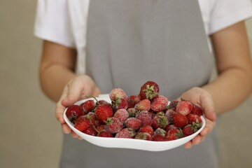 person holding bowl of fresh strawberries