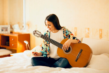 Woman writing song on bed