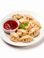 Plate of dumplings with tomato sauce on white background.