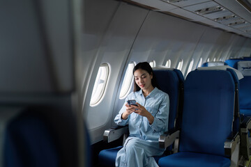 Asian people female person onboard, airplane window, using mobile while on the plane