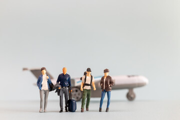 Fototapeta premium Miniature people, travelers embarks on a delightful vacation, gleefully boarding a tiny airplane